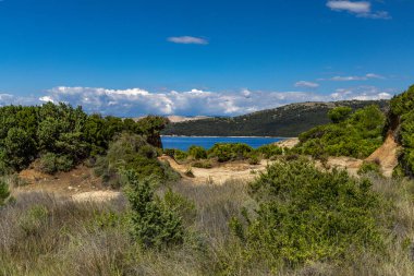 Kum tepeleri, kaya oluşumları ve Hırvatistan 'ın Rab adasındaki Ciganka doğabilimci plajına giden yol.