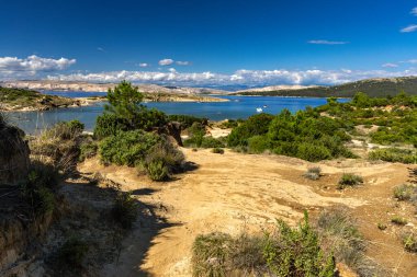 Kum tepeleri, kaya oluşumları ve Hırvatistan 'ın Rab adasındaki Ciganka doğabilimci plajına giden yol.