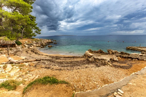 Tara Sahili, Rab, Adriyatik Denizi kıyısında güneş şemsiyeleri, bulutlu, tehditkar gökyüzü, gök mavisi su