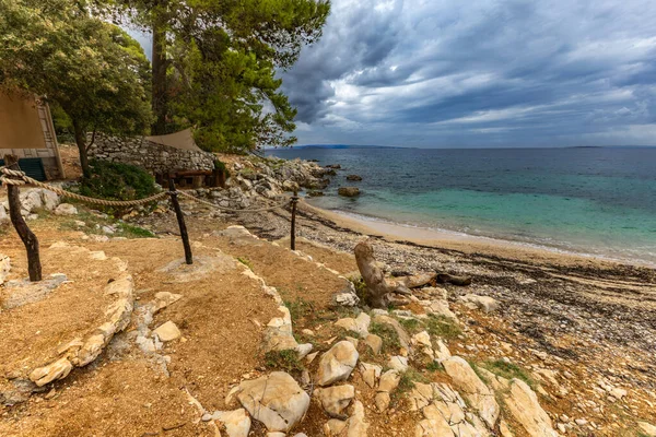Tara Sahili, Rab, Adriyatik Denizi kıyısında güneş şemsiyeleri, bulutlu, tehditkar gökyüzü, gök mavisi su