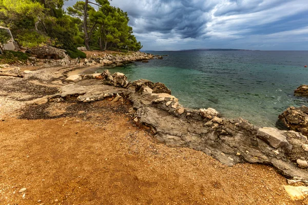 Tara Sahili, Rab, Adriyatik Denizi kıyısında güneş şemsiyeleri, bulutlu, tehditkar gökyüzü, gök mavisi su