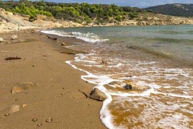Rab adasındaki Podsilo plajı, kumlu sahil, Moriatyckie 'den gelen dalgalar sahili, körfezin manzarası, kum ve dağlar.