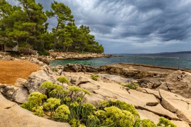 Rab adasındaki Tara Sahili, Adriyatik Denizi kıyısındaki Straw güneş şemsiyeleri, Croati
