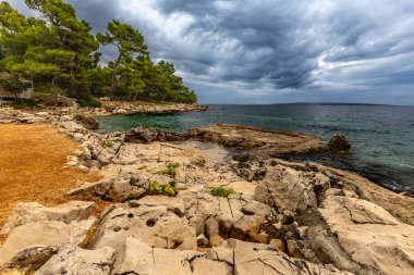 Rab adasındaki Tara Sahili, Adriyatik Denizi kıyısındaki Straw güneş şemsiyeleri, Croati