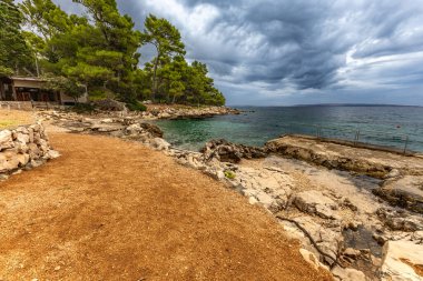 Rab adasındaki Tara Sahili, Adriyatik Denizi kıyısındaki Straw güneş şemsiyeleri, Croati