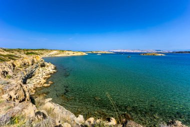 Rab Adası 'ndan FKK Ciganka plajına uzanan kayalık bir patika, Adriyatik Denizi' nin masmavi suları, Hırvatistan 'da bir yürüyüş noktası.