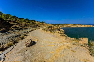 Rab Adası 'ndan FKK Ciganka plajına uzanan kayalık bir patika, Adriyatik Denizi' nin masmavi suları, Hırvatistan 'da bir yürüyüş noktası.