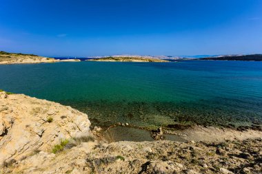 Rab Adası 'ndan FKK Ciganka plajına uzanan kayalık bir patika, Adriyatik Denizi' nin masmavi suları, Hırvatistan 'da bir yürüyüş noktası.
