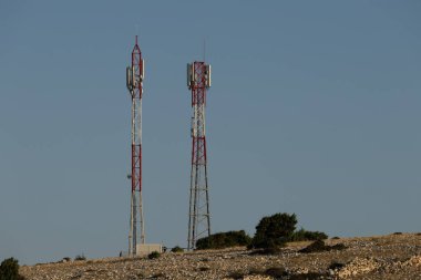 Ra adasındaki Lopar kasabasının yukarısındaki bir tepenin üzerinde televizyon ve radyo sinyalleri yayınlamak için iki uzun telekomünikasyon anten direği.