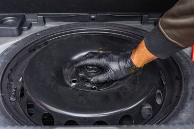 Arabanın bagajından yedek lastiği çıkarmak, Highwa 'da lastiği değiştirmek.