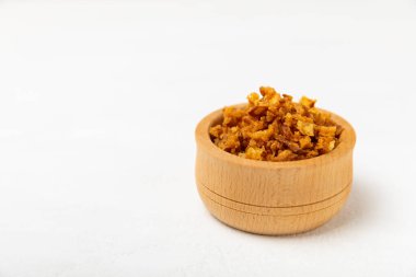 Tahta bir masada kasede kızarmış soğan. Kızarmış soğan. Bulaşık çeşnisi. Baharatlar. Salata sosu. Mesaj için yer var. Boşluğu kopyala