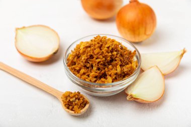 Tahta bir masada kasede kızarmış soğan. Kızarmış soğan. Bulaşık çeşnisi. Baharatlar. Salata sosu. Mesaj için yer var. Boşluğu kopyala