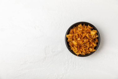 Tahta bir masada kasede kızarmış soğan. Kızarmış soğan. Bulaşık çeşnisi. Baharatlar. Salata sosu. Mesaj için yer var. Boşluğu kopyala