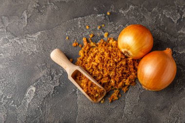 Tahta bir masada kasede kızarmış soğan. Kızarmış soğan. Bulaşık çeşnisi. Baharatlar. Salata sosu. Mesaj için yer var. Boşluğu kopyala