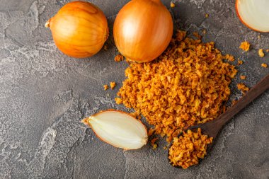 Tahta bir masada kasede kızarmış soğan. Kızarmış soğan. Bulaşık çeşnisi. Baharatlar. Salata sosu. Mesaj için yer var. Boşluğu kopyala