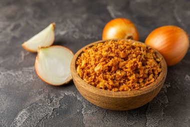 Tahta bir masada kasede kızarmış soğan. Kızarmış soğan. Bulaşık çeşnisi. Baharatlar. Salata sosu. Mesaj için yer var. Boşluğu kopyala