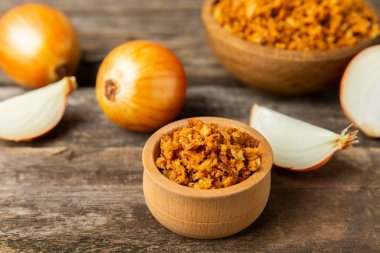 Tahta bir masada kasede kızarmış soğan. Kızarmış soğan. Bulaşık çeşnisi. Baharatlar. Salata sosu. Mesaj için yer var. Boşluğu kopyala