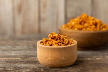 Tahta bir masada kasede kızarmış soğan. Kızarmış soğan. Bulaşık çeşnisi. Baharatlar. Salata sosu. Mesaj için yer var. Boşluğu kopyala