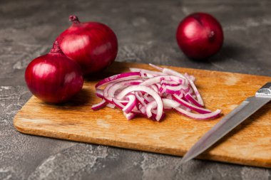 Mutfak masasında Shallot soğanı. Soğan dilimi. Soğan halkaları. Taze kırmızı soğan. Doğal, taze, vejetaryen yiyecekler. Tarım ürünleri. Sağlıklı beslenme. Sebzeler. Çiftçi pazarı..