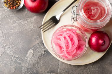 Masadaki cam kavanozda soğan turşusu. Kırmızı soğan turşusu. Vejetaryen baharatlı yemek. Lezzetli ev yapımı marine edilmiş mor soğan turşusu. Mesaj için yer var. Boşluğu kopyala.