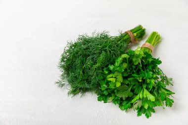 Doku masasında Dill ve Maydanoz. Maydanozla dereotu karıştırdım. Taze aromalı baharatlı sebzeler. Baharatlar ve bitkiler. Mesaj için yer var. Boşluğu kopyala