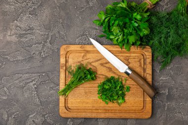 Doku masasında Dill ve Maydanoz. Maydanozla dereotu karıştırdım. Taze aromalı baharatlı sebzeler. Baharatlar ve bitkiler. Mesaj için yer var. Boşluğu kopyala