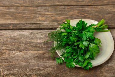 Doku masasında Dill ve Maydanoz. Maydanozla dereotu karıştırdım. Taze aromalı baharatlı sebzeler. Baharatlar ve bitkiler. Mesaj için yer var. Boşluğu kopyala