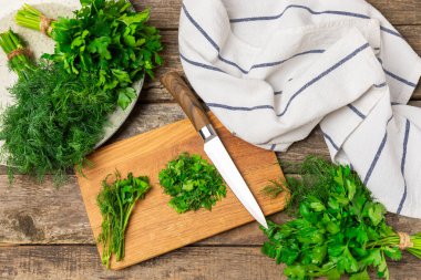 Doku masasında Dill ve Maydanoz. Maydanozla dereotu karıştırdım. Taze aromalı baharatlı sebzeler. Baharatlar ve bitkiler. Mesaj için yer var. Boşluğu kopyala