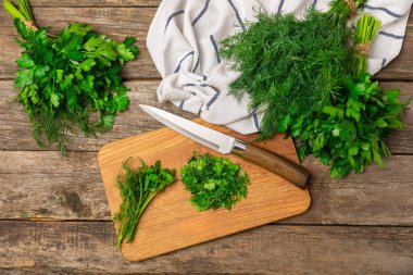 Doku masasında Dill ve Maydanoz. Maydanozla dereotu karıştırdım. Taze aromalı baharatlı sebzeler. Baharatlar ve bitkiler. Mesaj için yer var. Boşluğu kopyala