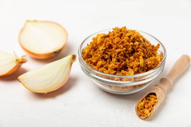 Tahta bir masada kasede kızarmış soğan. Kızarmış soğan. Bulaşık çeşnisi. Baharatlar. Salata sosu. Mesaj için yer var. Boşluğu kopyala