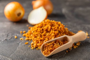 Tahta bir masada kasede kızarmış soğan. Kızarmış soğan. Bulaşık çeşnisi. Baharatlar. Salata sosu. Mesaj için yer var. Boşluğu kopyala