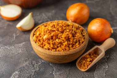 Tahta bir masada kasede kızarmış soğan. Kızarmış soğan. Bulaşık çeşnisi. Baharatlar. Salata sosu. Mesaj için yer var. Boşluğu kopyala