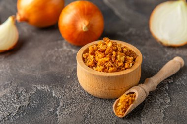 Tahta bir masada kasede kızarmış soğan. Kızarmış soğan. Bulaşık çeşnisi. Baharatlar. Salata sosu. Mesaj için yer var. Boşluğu kopyala