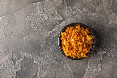 Tahta bir masada kasede kızarmış soğan. Kızarmış soğan. Bulaşık çeşnisi. Baharatlar. Salata sosu. Mesaj için yer var. Boşluğu kopyala