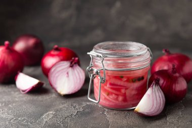 Masadaki cam kavanozda soğan turşusu. Kırmızı soğan turşusu. Vejetaryen baharatlı yemek. Lezzetli ev yapımı marine edilmiş mor soğan turşusu. Mesaj için yer var. Boşluğu kopyala.