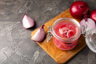 Masadaki cam kavanozda soğan turşusu. Kırmızı soğan turşusu. Vejetaryen baharatlı yemek. Lezzetli ev yapımı marine edilmiş mor soğan turşusu. Mesaj için yer var. Boşluğu kopyala.