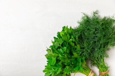 Doku masasında Dill ve Maydanoz. Maydanozla dereotu karıştırdım. Taze aromalı baharatlı sebzeler. Baharatlar ve bitkiler. Mesaj için yer var. Boşluğu kopyala