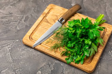 Doku masasında Dill ve Maydanoz. Maydanozla dereotu karıştırdım. Taze aromalı baharatlı sebzeler. Baharatlar ve bitkiler. Mesaj için yer var. Boşluğu kopyala