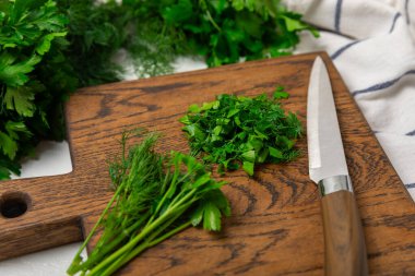 Doku masasında Dill ve Maydanoz. Maydanozla dereotu karıştırdım. Taze aromalı baharatlı sebzeler. Baharatlar ve bitkiler. Mesaj için yer var. Boşluğu kopyala