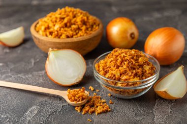 Tahta bir masada kasede kızarmış soğan. Kızarmış soğan. Bulaşık çeşnisi. Baharatlar. Salata sosu. Mesaj için yer var. Boşluğu kopyala