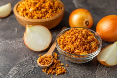 Tahta bir masada kasede kızarmış soğan. Kızarmış soğan. Bulaşık çeşnisi. Baharatlar. Salata sosu. Mesaj için yer var. Boşluğu kopyala