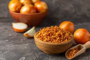 Tahta bir masada kasede kızarmış soğan. Kızarmış soğan. Bulaşık çeşnisi. Baharatlar. Salata sosu. Mesaj için yer var. Boşluğu kopyala