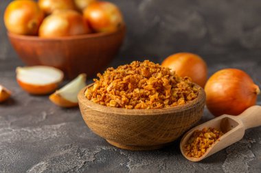 Tahta bir masada kasede kızarmış soğan. Kızarmış soğan. Bulaşık çeşnisi. Baharatlar. Salata sosu. Mesaj için yer var. Boşluğu kopyala