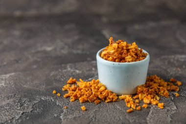 Tahta bir masada kasede kızarmış soğan. Kızarmış soğan. Bulaşık çeşnisi. Baharatlar. Salata sosu. Mesaj için yer var. Boşluğu kopyala