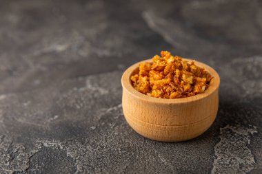 Tahta bir masada kasede kızarmış soğan. Kızarmış soğan. Bulaşık çeşnisi. Baharatlar. Salata sosu. Mesaj için yer var. Boşluğu kopyala