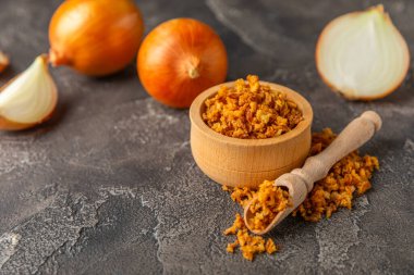 Tahta bir masada kasede kızarmış soğan. Kızarmış soğan. Bulaşık çeşnisi. Baharatlar. Salata sosu. Mesaj için yer var. Boşluğu kopyala