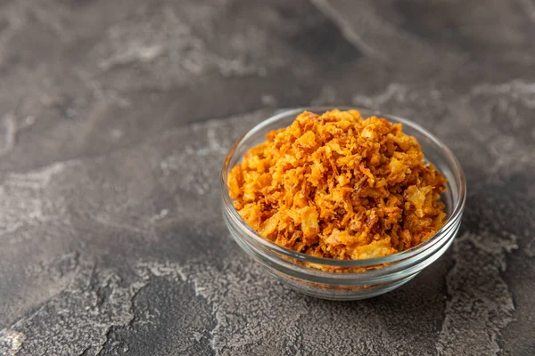 Tahta bir masada kasede kızarmış soğan. Kızarmış soğan. Bulaşık çeşnisi. Baharatlar. Salata sosu. Mesaj için yer var. Boşluğu kopyala