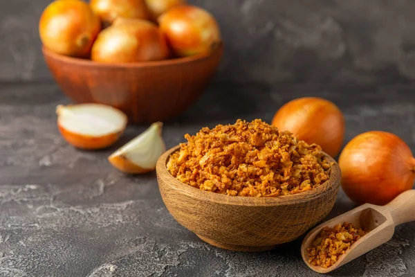 Tahta bir masada kasede kızarmış soğan. Kızarmış soğan. Bulaşık çeşnisi. Baharatlar. Salata sosu. Mesaj için yer var. Boşluğu kopyala