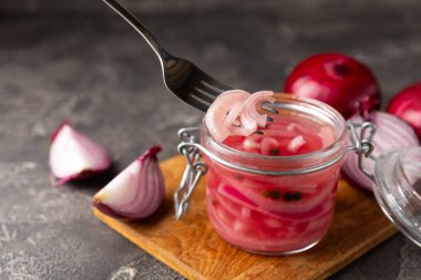 Masadaki cam kavanozda soğan turşusu. Kırmızı soğan turşusu. Vejetaryen baharatlı yemek. Lezzetli ev yapımı marine edilmiş mor soğan turşusu. Mesaj için yer var. Boşluğu kopyala.