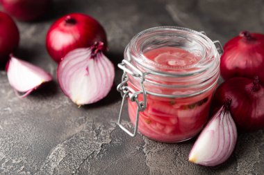 Masadaki cam kavanozda soğan turşusu. Kırmızı soğan turşusu. Vejetaryen baharatlı yemek. Lezzetli ev yapımı marine edilmiş mor soğan turşusu. Mesaj için yer var. Boşluğu kopyala.